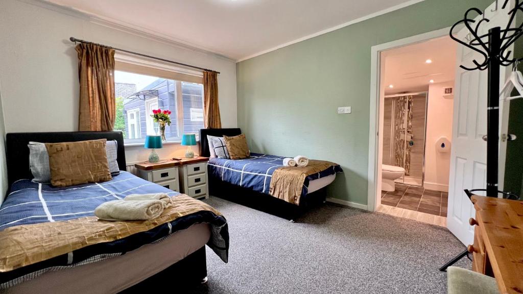 um quarto com 2 camas e uma casa de banho em Old Captain Guest House em Portree