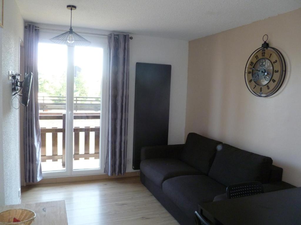 a living room with a couch and a large window at Risoul 1850 appartement 4 personnes proches pistes. in Risoul