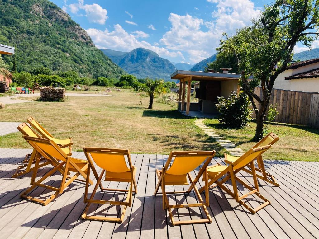 een groep stoelen op een terras met bergen op de achtergrond bij Le Domaine d'Arignac - La grande maison in Arignac