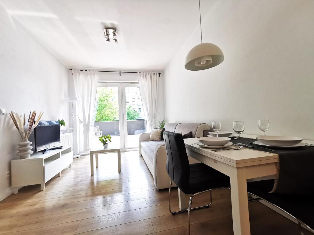 a living room with a table and a couch at Matejki Apartment ~ Self Check-In 24 ~ Parking in Wrocław