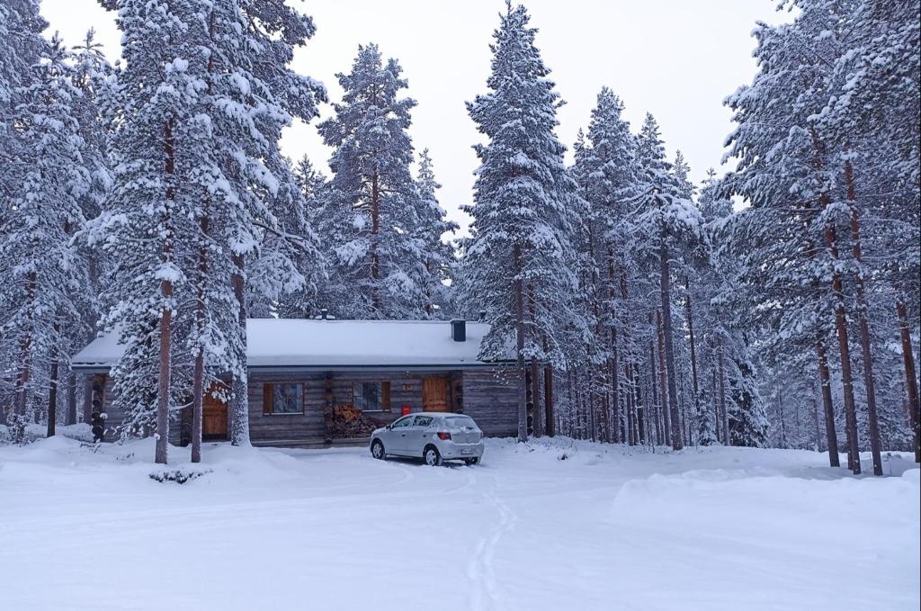 um carro estacionado em frente a uma cabana na neve em Kelomökki Sallatunturissa em Salla