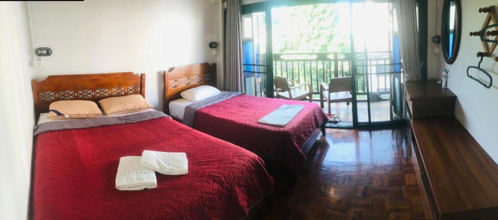 a bedroom with two beds and a balcony at Bee Friend Hostel in Chiang Mai