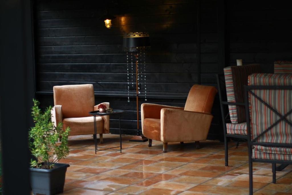 Zimmer mit 2 Stühlen und einem Tisch auf einer Etage in der Unterkunft Hotel უცხო-utskho in Telawi