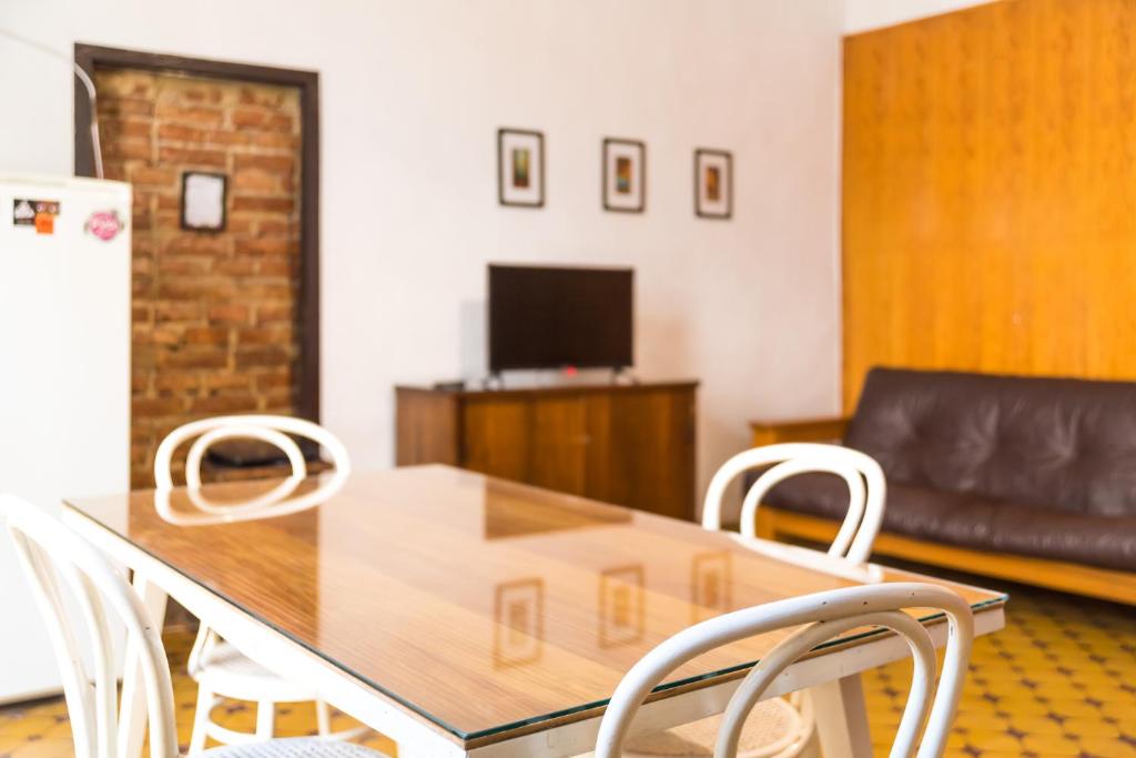 a dining room with a table and white chairs at Alojamiento Aloja N1 in Mendoza