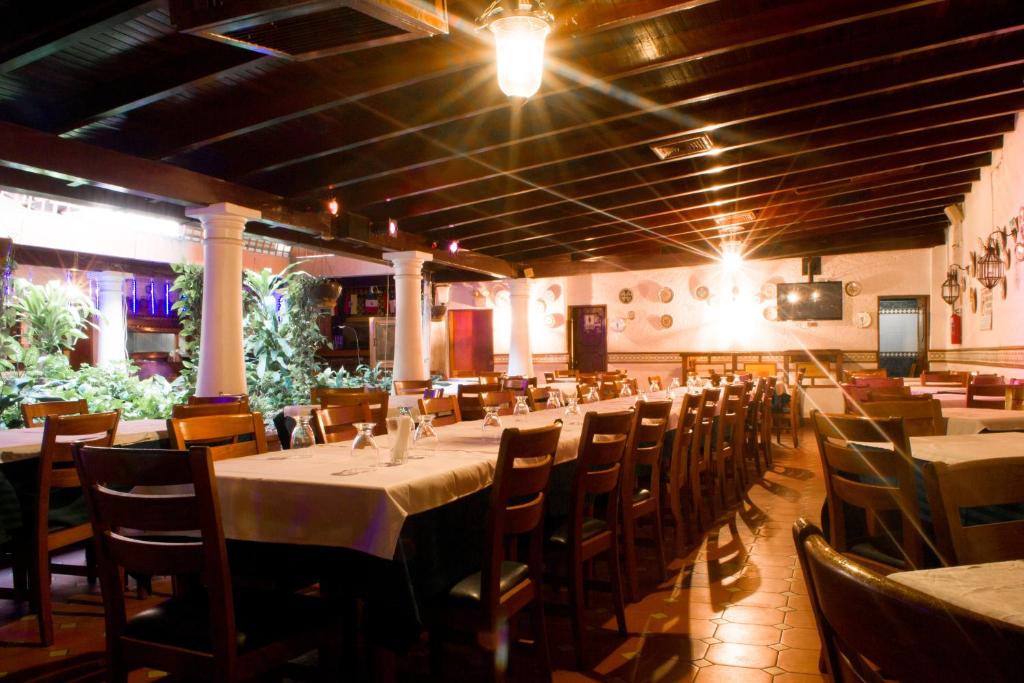 a restaurant with tables and chairs in a room at Hotel El Arroyo in Caracas