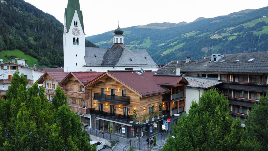 a building with a clock tower and a church at Appartments Das Franzal in Zell am Ziller