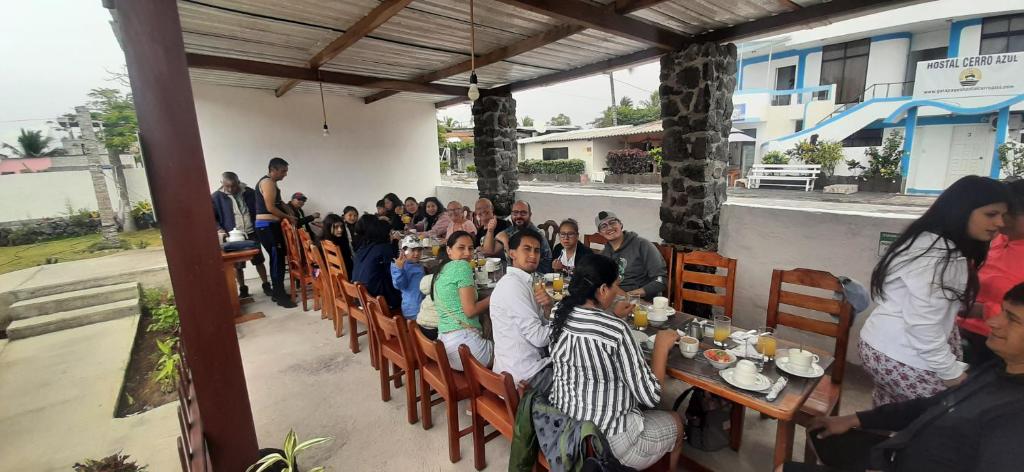 eine Gruppe von Personen, die in einem Restaurant an Tischen sitzen in der Unterkunft HOSTAL TERO REAL in Puerto Villamil