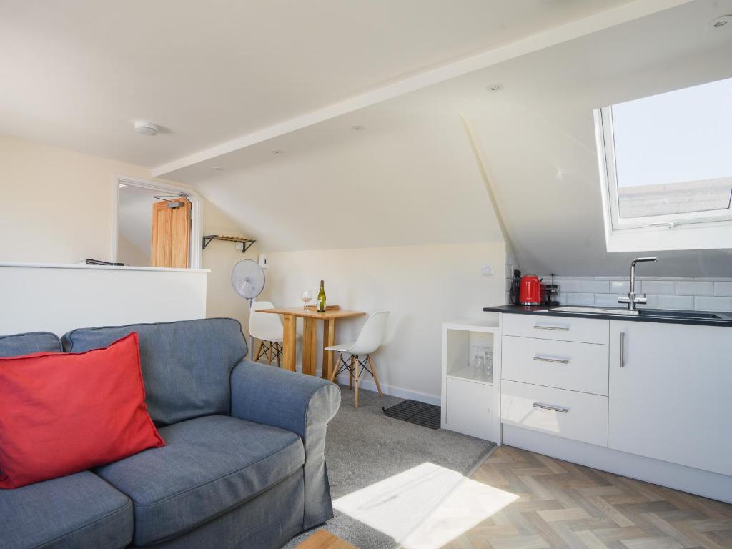 a living room with a couch and a kitchen at Ayla in Lyme Regis