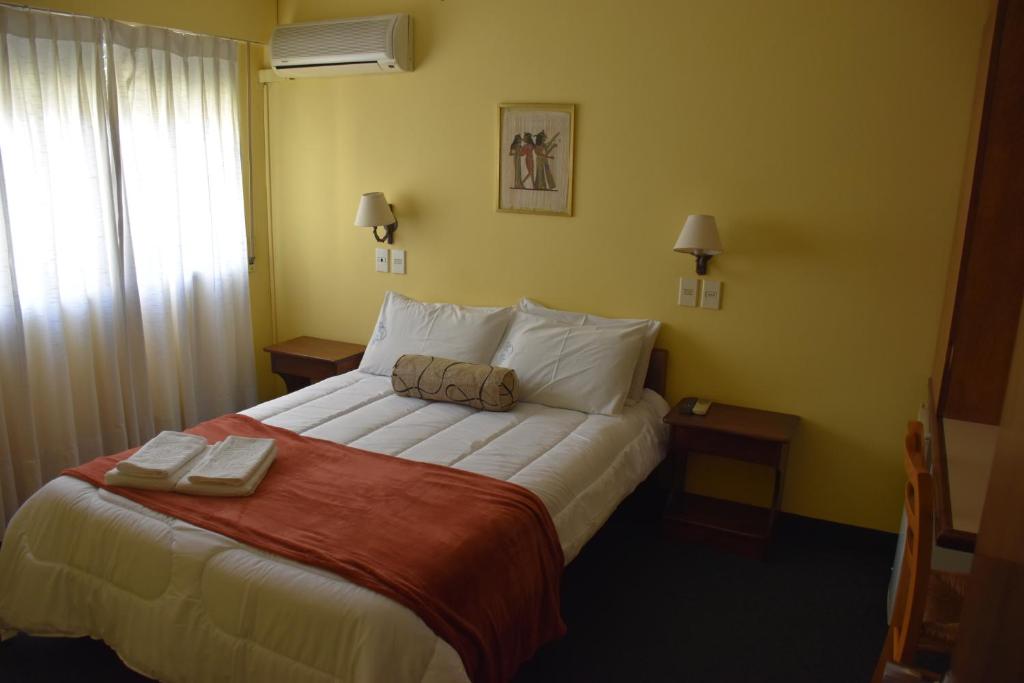 a bedroom with a large bed with two towels on it at Hotel Sol Colonia in Colonia del Sacramento