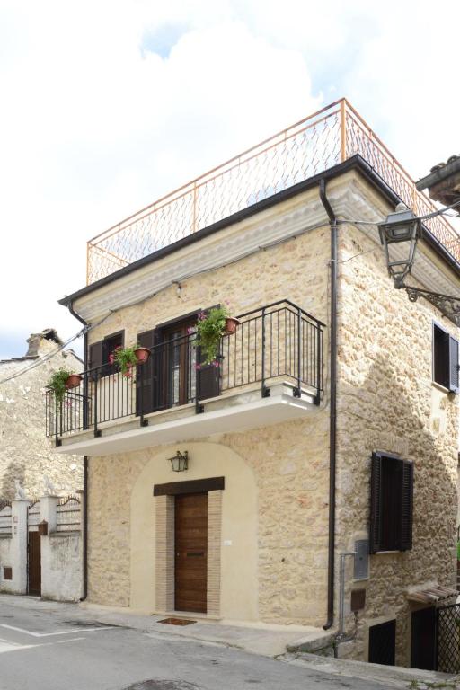 a building with a balcony with plants on it at Casa Vacanza Orto dei Preti in Collepardo