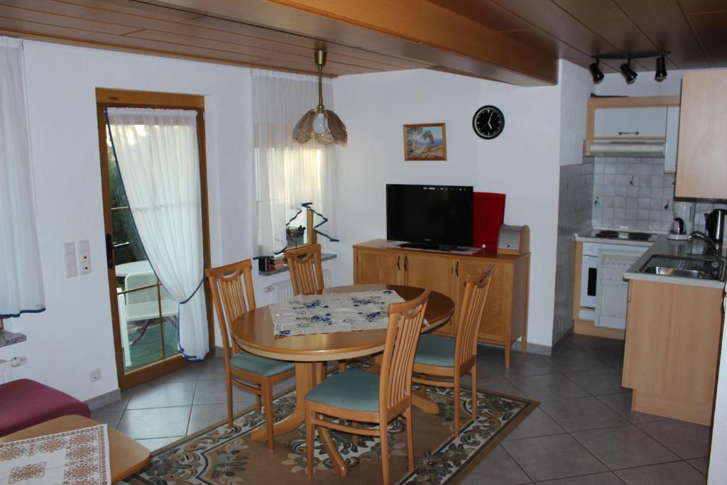 een keuken en eetkamer met een tafel en stoelen bij Bodenseegästehaus in Uhldingen-Mühlhofen