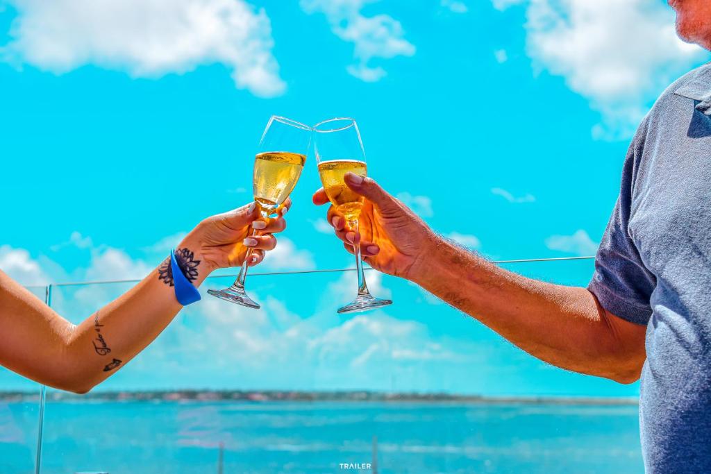 a man and a woman holding glasses of champagne at Hotel Aracaju Suites in Aracaju