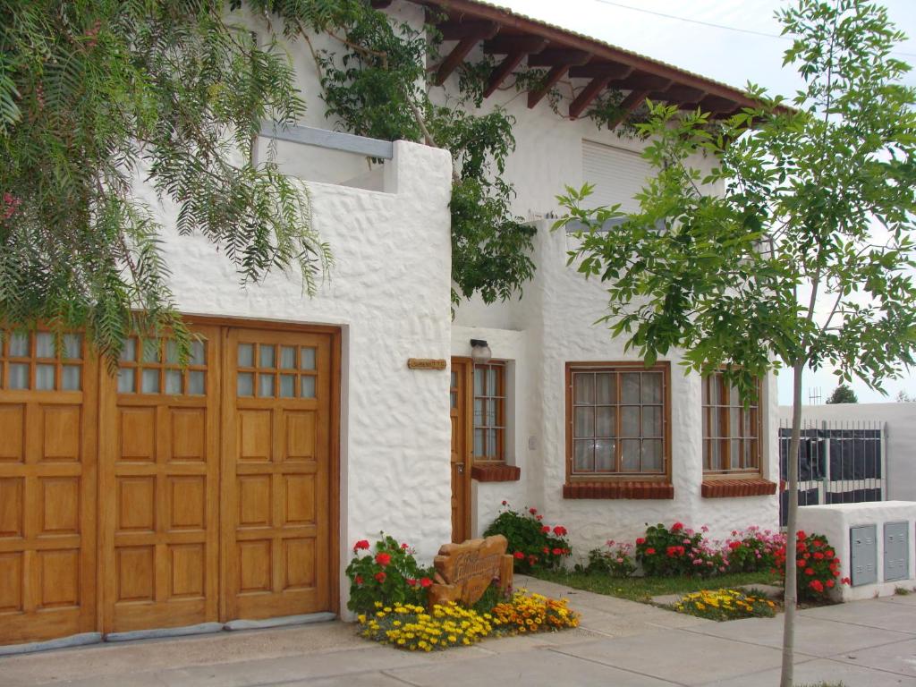 a white house with a wooden garage at Calfulauquen in Las Grutas