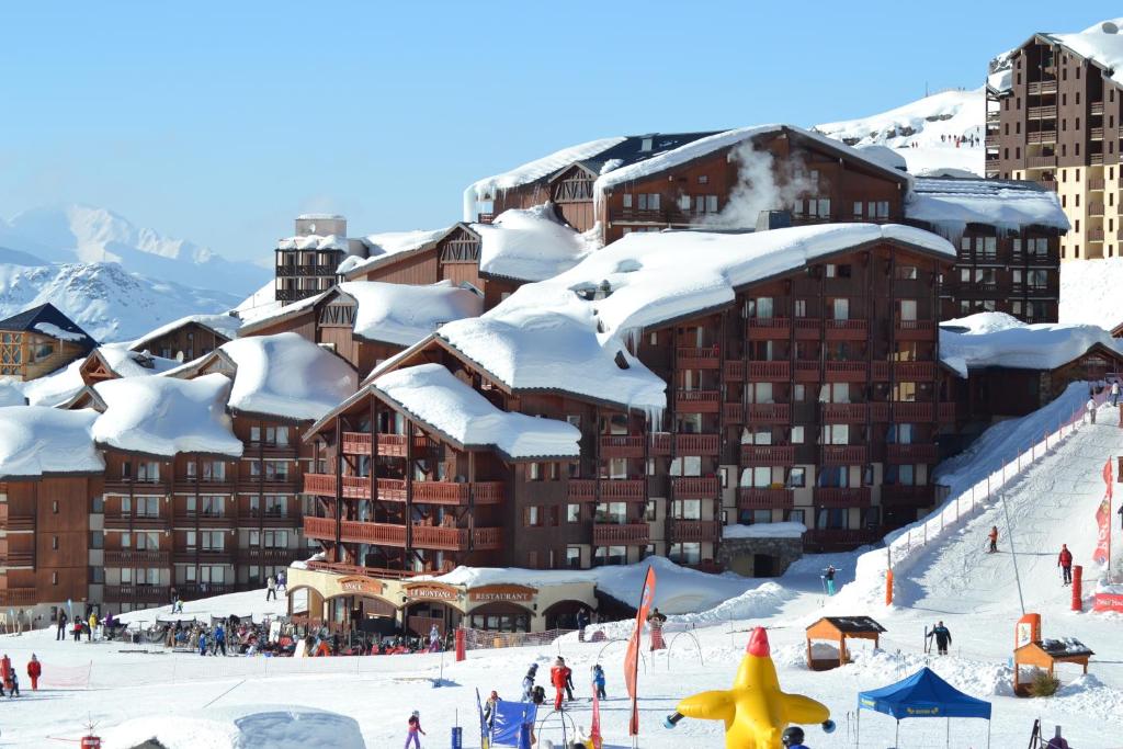 a ski resort with snow covered buildings and people on the slopes at Résidence Montana Premier in Val Thorens