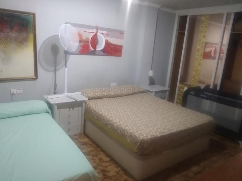 ein kleines Schlafzimmer mit 2 Betten und einem Spiegel in der Unterkunft Piso entero cerca de Valencia y sus playas. in Albalat dels Sorells