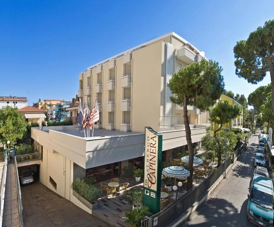 a building with an american flag on top of it at Hotel Capinera in Rimini