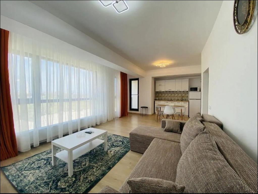 a living room with a couch and a table at Alezzi Yacht Apartments with Sea View Near the Beach in Năvodari