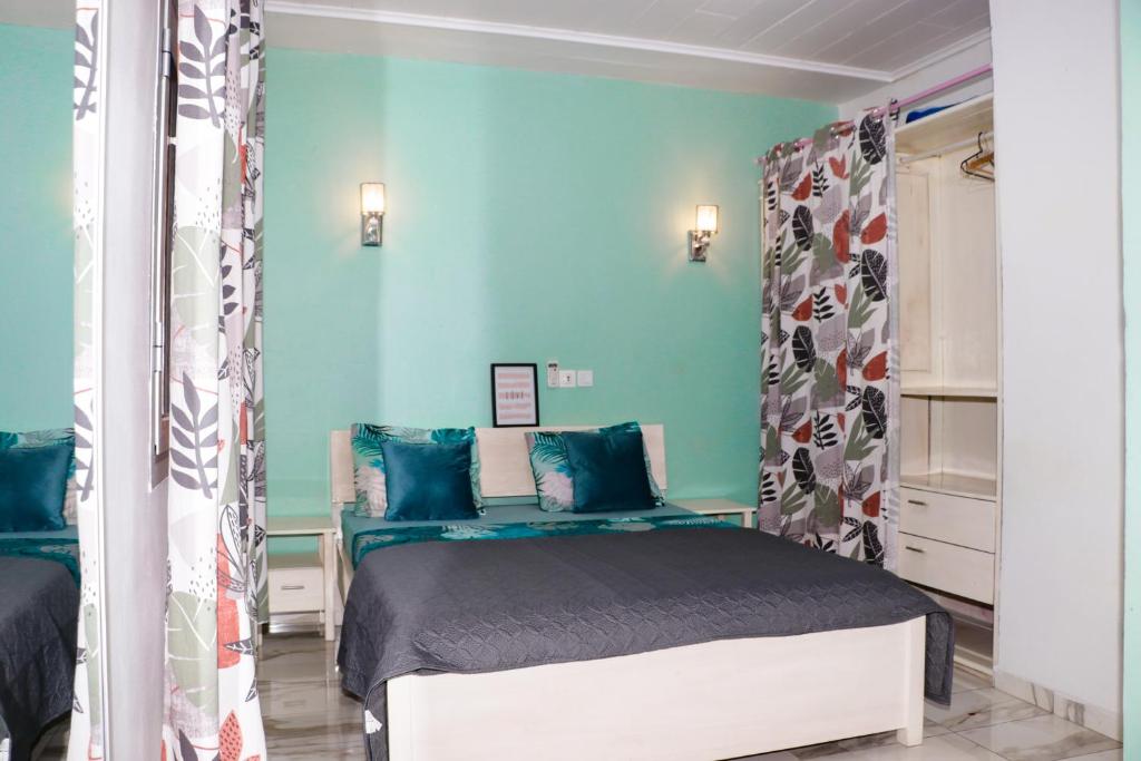 um quarto com uma cama e uma parede azul em ENJOY n RELAX em Douala