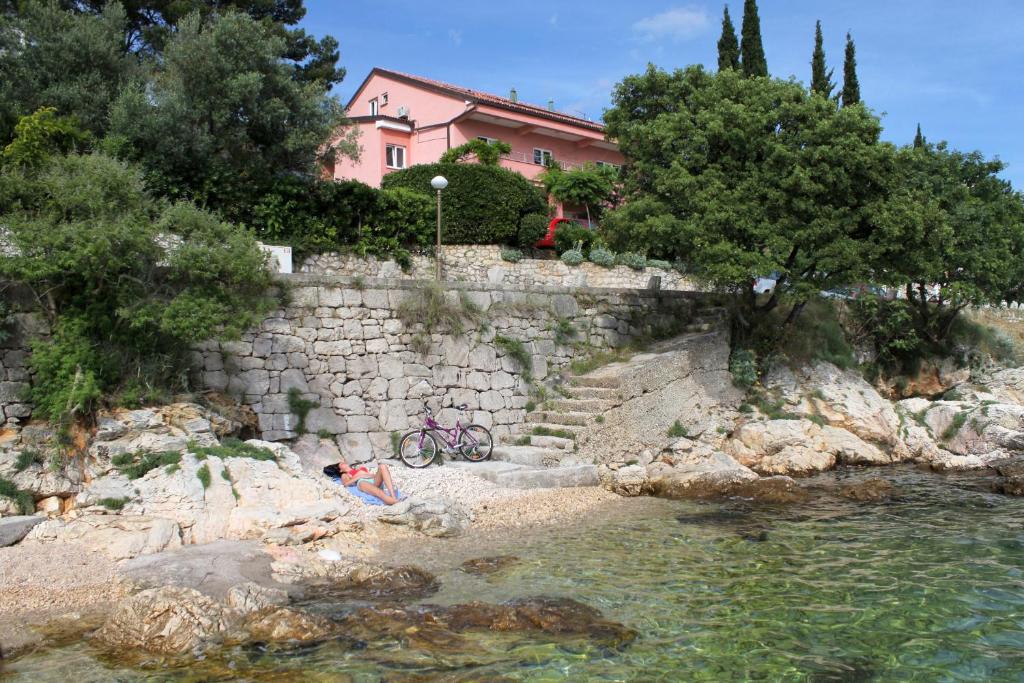 a house sitting on a stone wall next to a river at Apartments by the sea Crikvenica - 2354 in Crikvenica