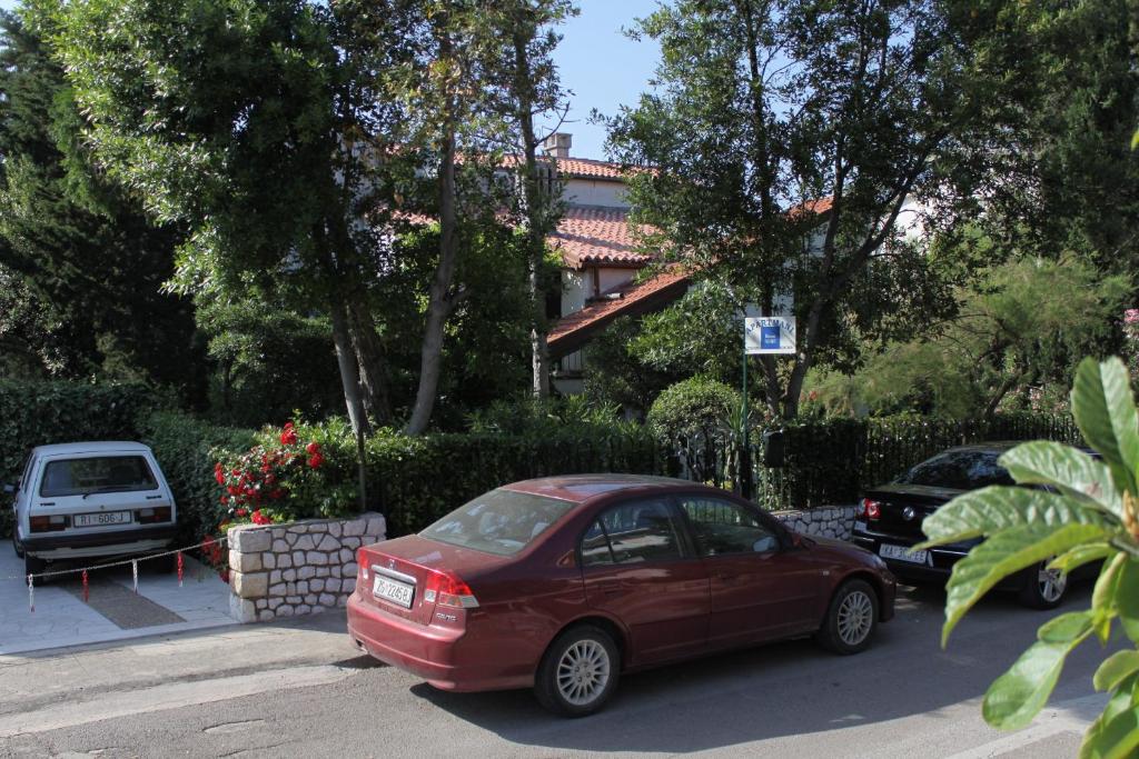 a red car parked on the side of a street at Apartments by the sea Selce, Crikvenica - 2372 in Selce