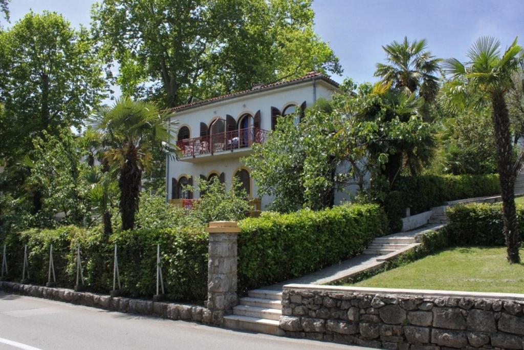 a white house with a fence and trees at Apartments and rooms with parking space Lovran, Opatija - 2341 in Lovran