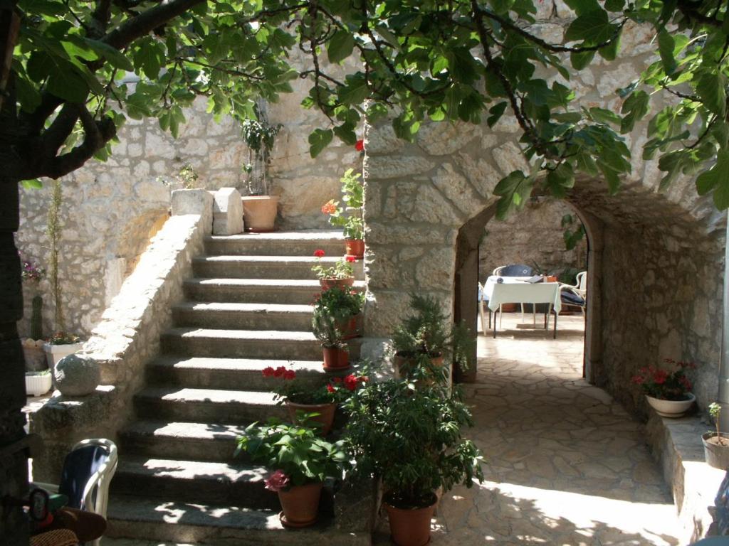 a stone staircase with potted plants and a table at Studio Novi Vinodolski 2382a in Novi Vinodolski
