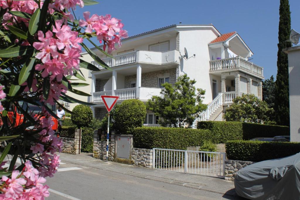 a white house with a yield sign in front of it at Apartments by the sea Selce, Crikvenica - 2392 in Selce
