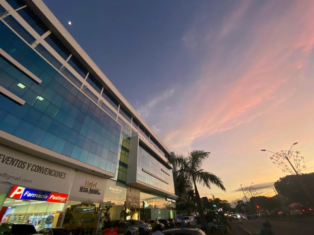 ein großes Gebäude mit einer Palme davor in der Unterkunft Hotel Sexta Avenida Inn in Montería