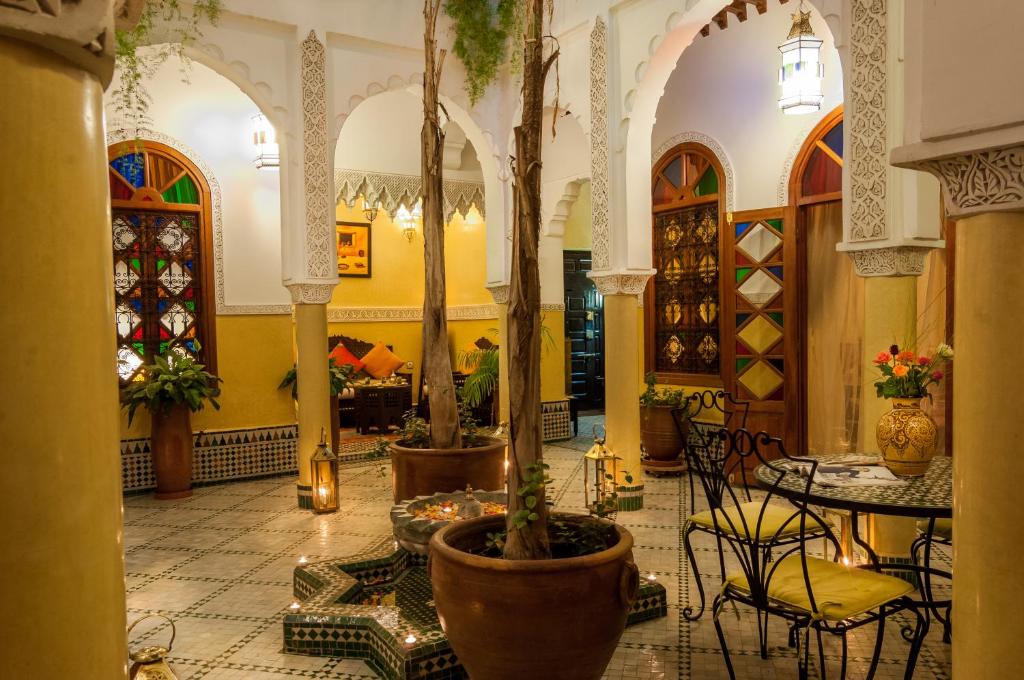 een lobby met potbomen en tafels en stoelen bij Riad Bab Agnaou & Spa in Marrakesh