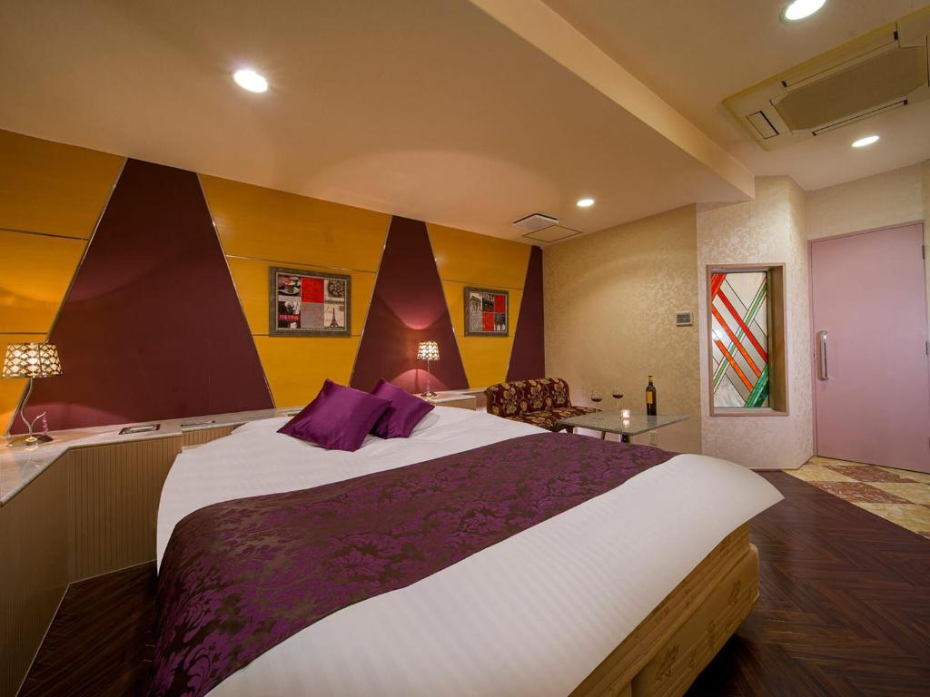 una camera da letto con un grande letto con cuscini viola di HOTEL U's Kouroen - Vacation STAY 11230v a Nishinomiya
