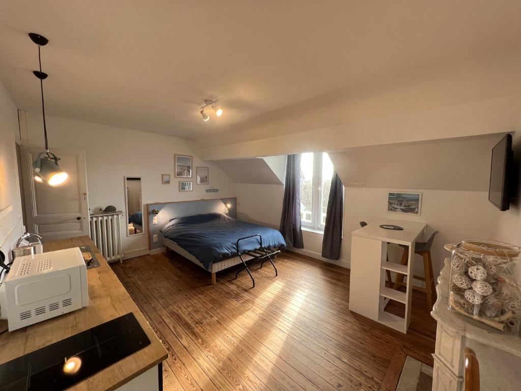 een kleine slaapkamer met een bed en een keuken bij Le Manoir des Lys in Tilly-sur-Seulles