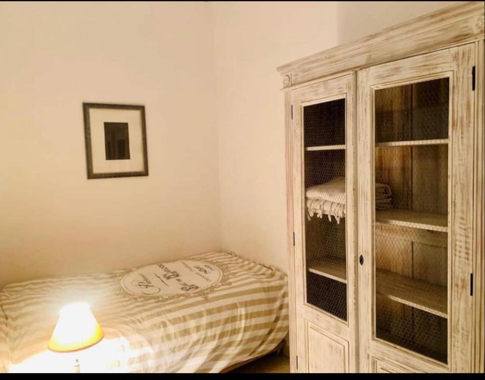 1 dormitorio con armario y 1 cama con lámpara en Au cœur de Cannes, à l’angle de la rue d’Antibes, en Cannes
