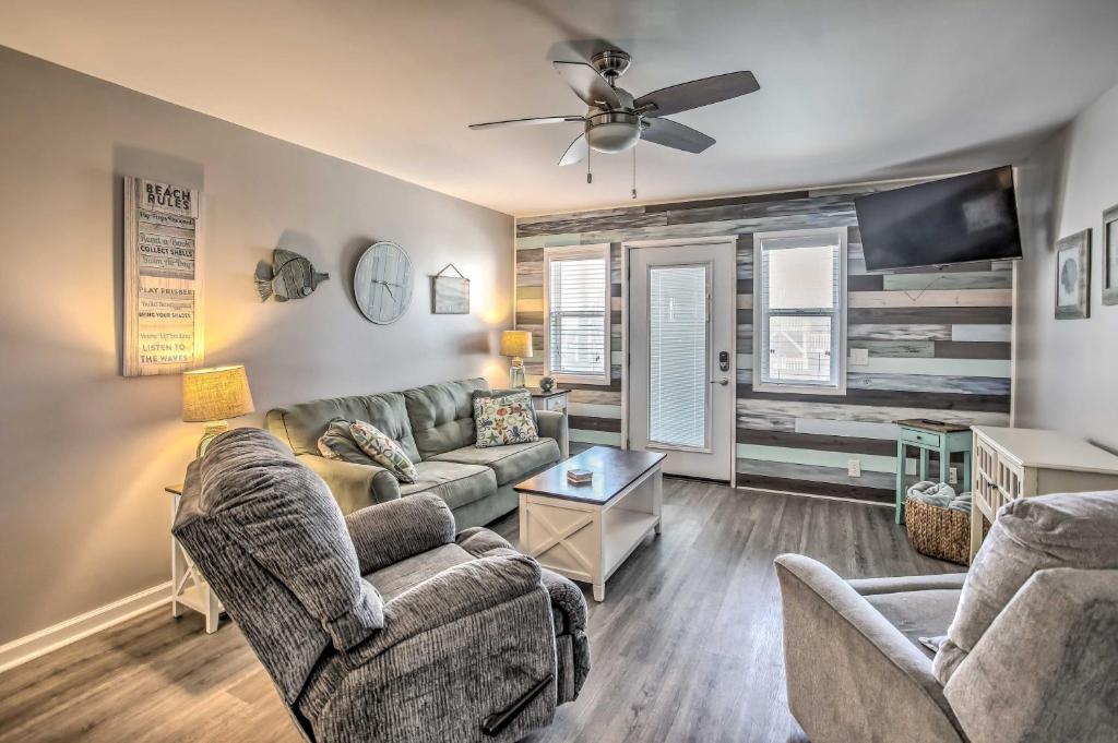 a living room with couches and a flat screen tv at Waterfront Ocean Isle Beach Condo with Balcony! in Ocean Isle Beach