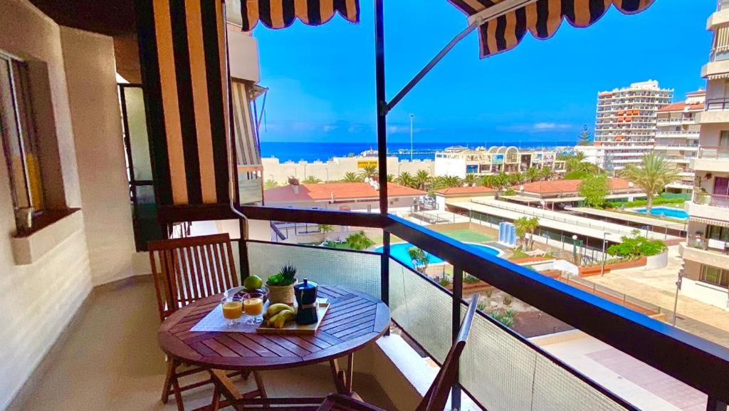 a table on a balcony with a view of the ocean at Vistas al mar Jardines Canarios Los Cristianos in Los Cristianos