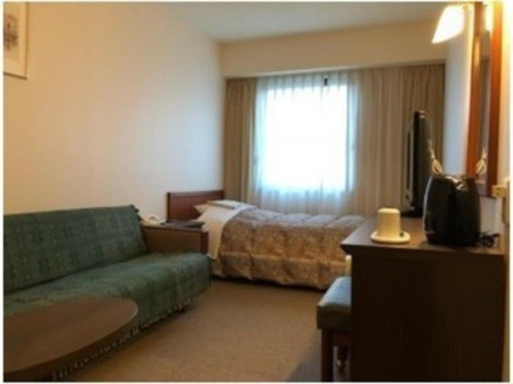a hotel room with a couch and a bed at Grand Plaza Nakatsu Hotel - Vacation STAY 28283v in Nakatsu
