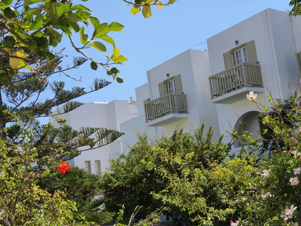 a building with balconies and trees in the foreground at Vidalis Hotel in Kionia