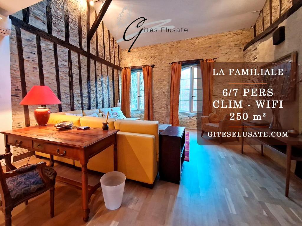 een woonkamer met een gele bank en een tafel bij Gîtes Elusate in Eauze