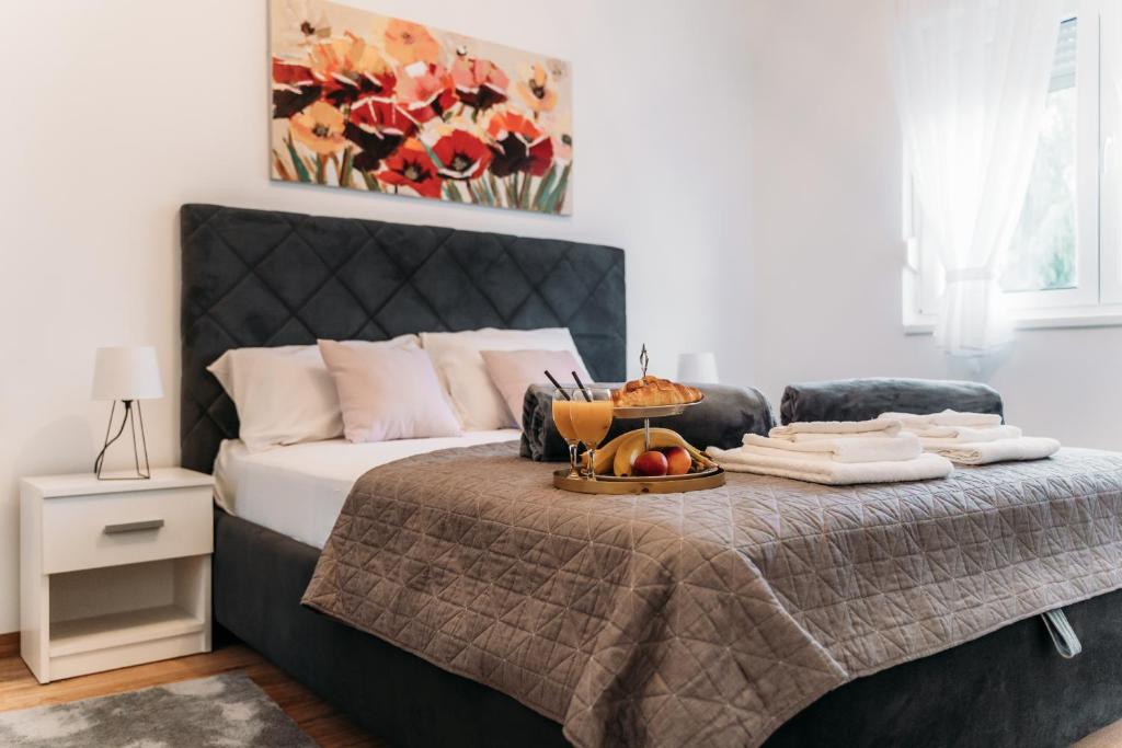 Un dormitorio con una cama con una bandeja de comida. en Apartman Star #1 en Vinkovci