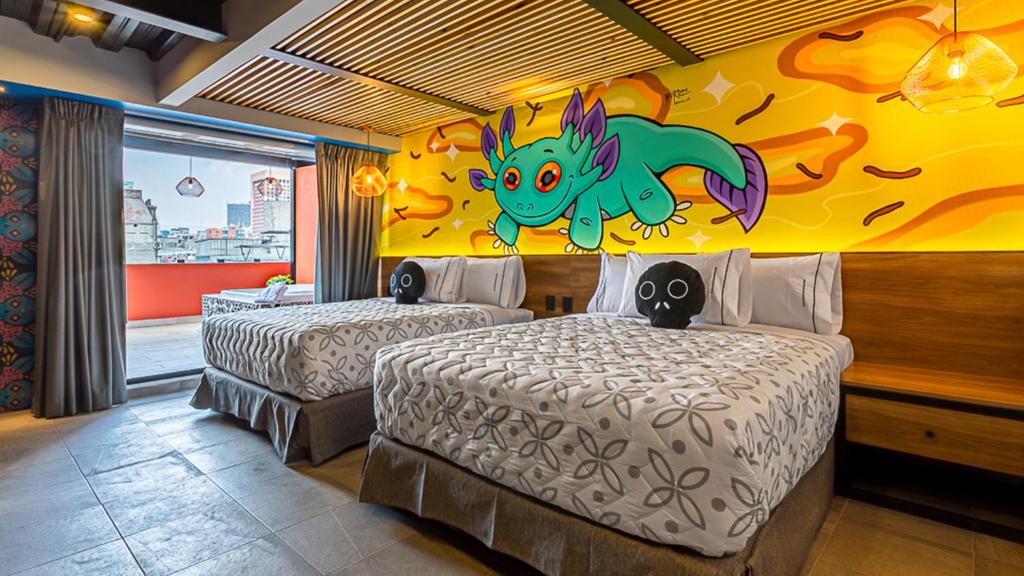 1 dormitorio con 2 camas y un dragón en la pared en Barrio Downtown Mexico City Hostel en Ciudad de México