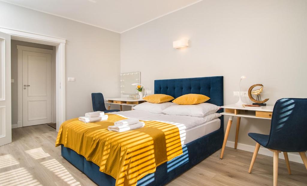 - une chambre avec un lit bleu et jaune et un bureau dans l'établissement Apartament na Wspólnej, à Elbląg