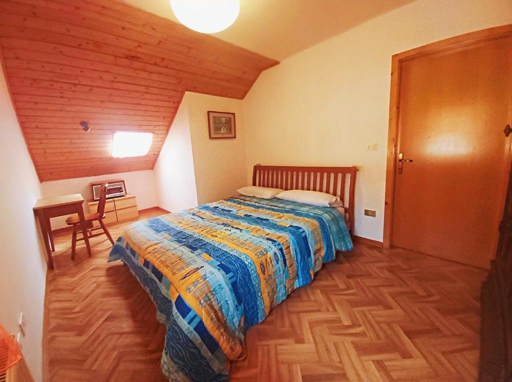 a bedroom with a bed in a room with a table at Alloggio Matrimoniale vicino Asiago (Roana) in Roana