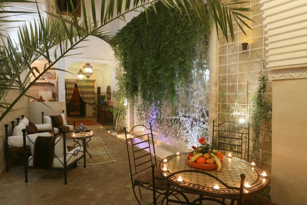 una habitación con mesas, sillas y una fuente en Riad El Bellar, en Marrakech