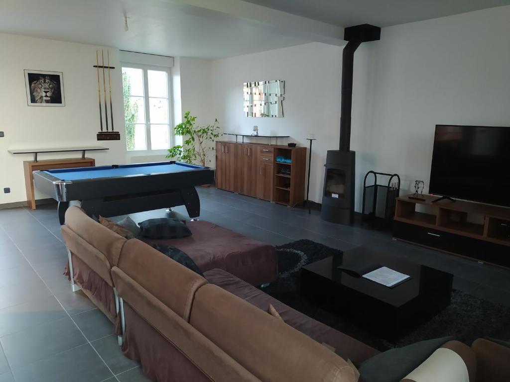 a living room with a couch and a pool table at DS Harmothe in Chamouille