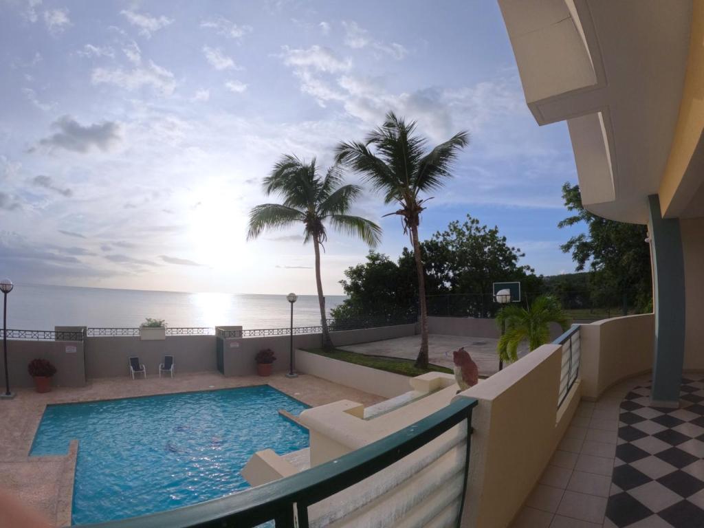 a view of the pool from the balcony of a resort at Beachfront Apartment In Joyuda With Pool And Basketball Court in Cabo Rojo