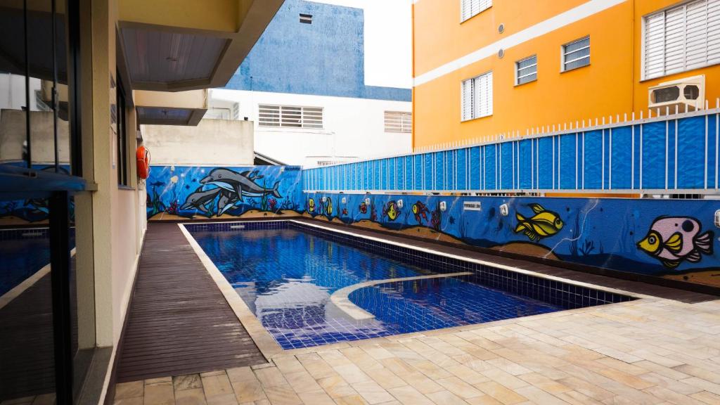uma piscina num edifício com um mural em HANNA San Diego Apart Hotel em Florianópolis