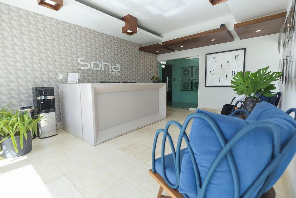 un salón con una sala de espera con sillas azules en Soha suites I, en Santiago de los Caballeros