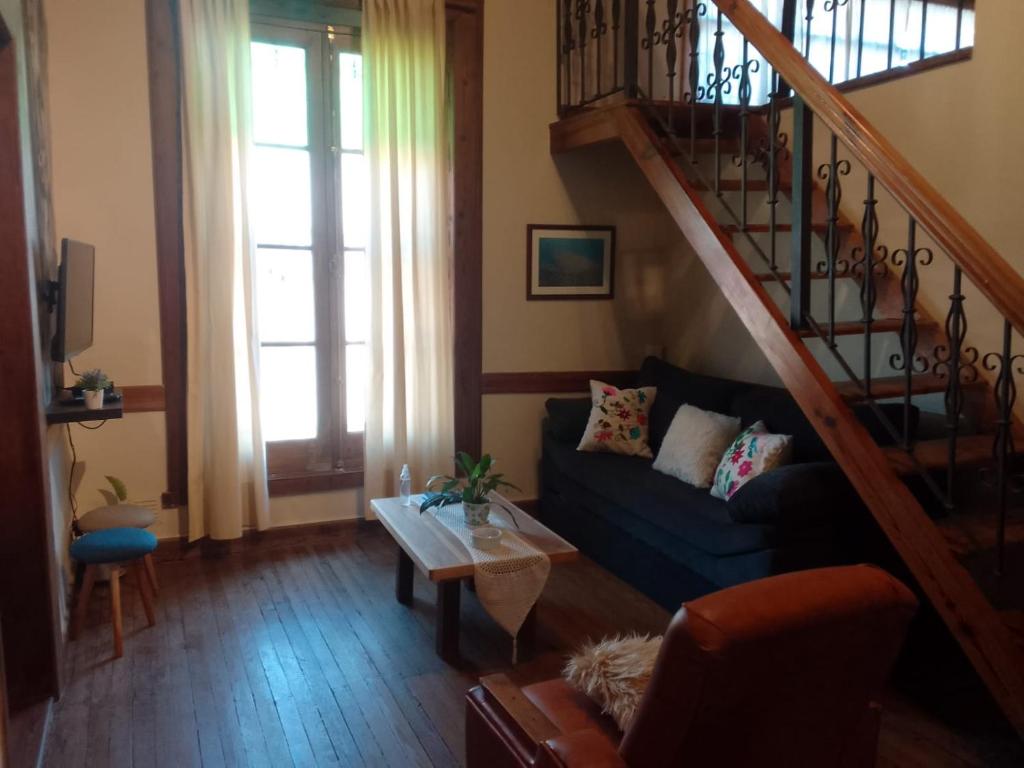 sala de estar con sofá azul y escalera en Casa Araucaria en Concepción del Uruguay