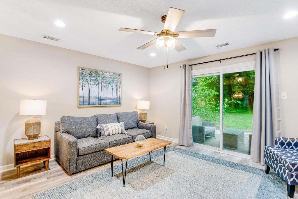 a living room with a couch and a ceiling fan at The Wilmington Condos Island in Savannah