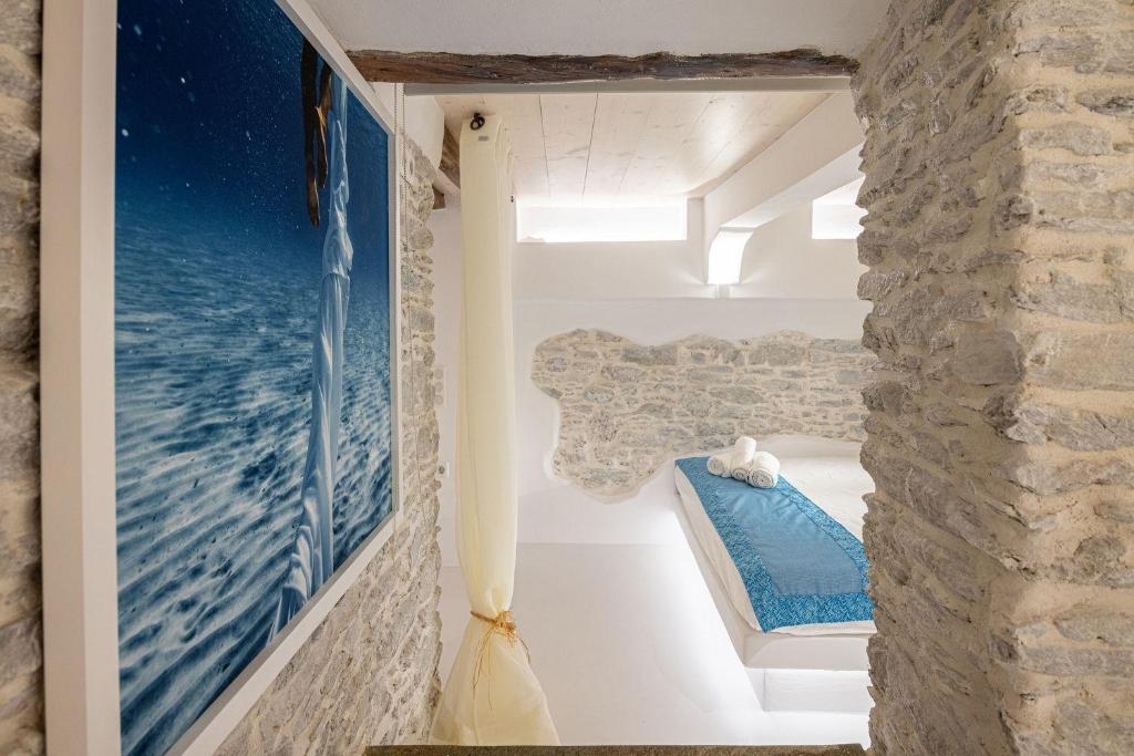 a room with a painting of the ocean on the wall at Margaret's Houses in TINOS Town in Tinos Town