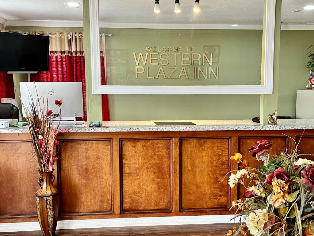 a sign that reads western pizza inn above a reception desk at Western Plaza Inn in De Queen